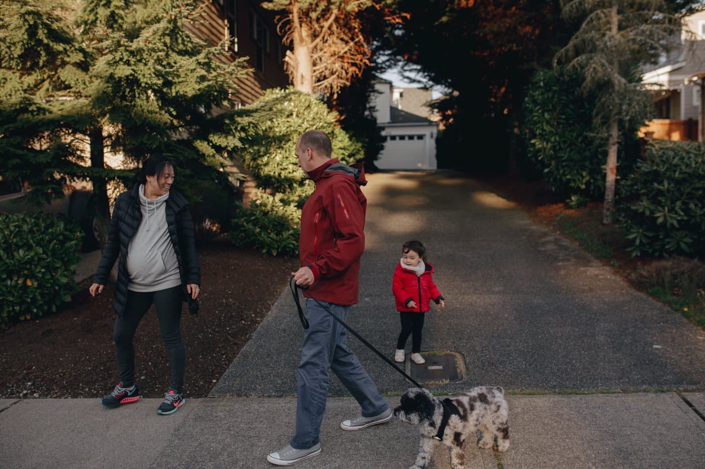 A family walking the dog down their clean driveway. A photo from Kingfisher Exterior Cleaning, the sample pressure washing website.