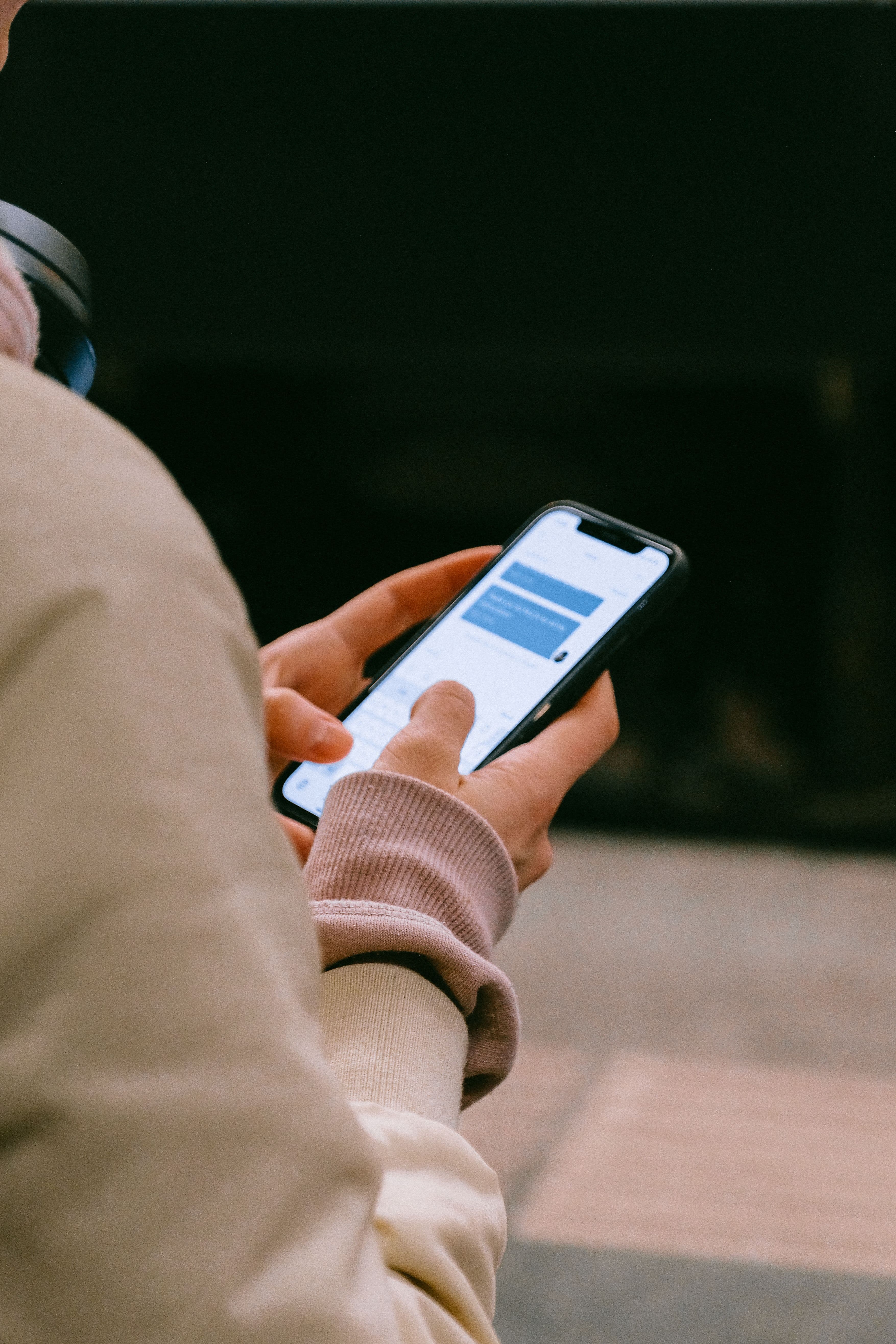 A person holding a smartphone in both hands, typing