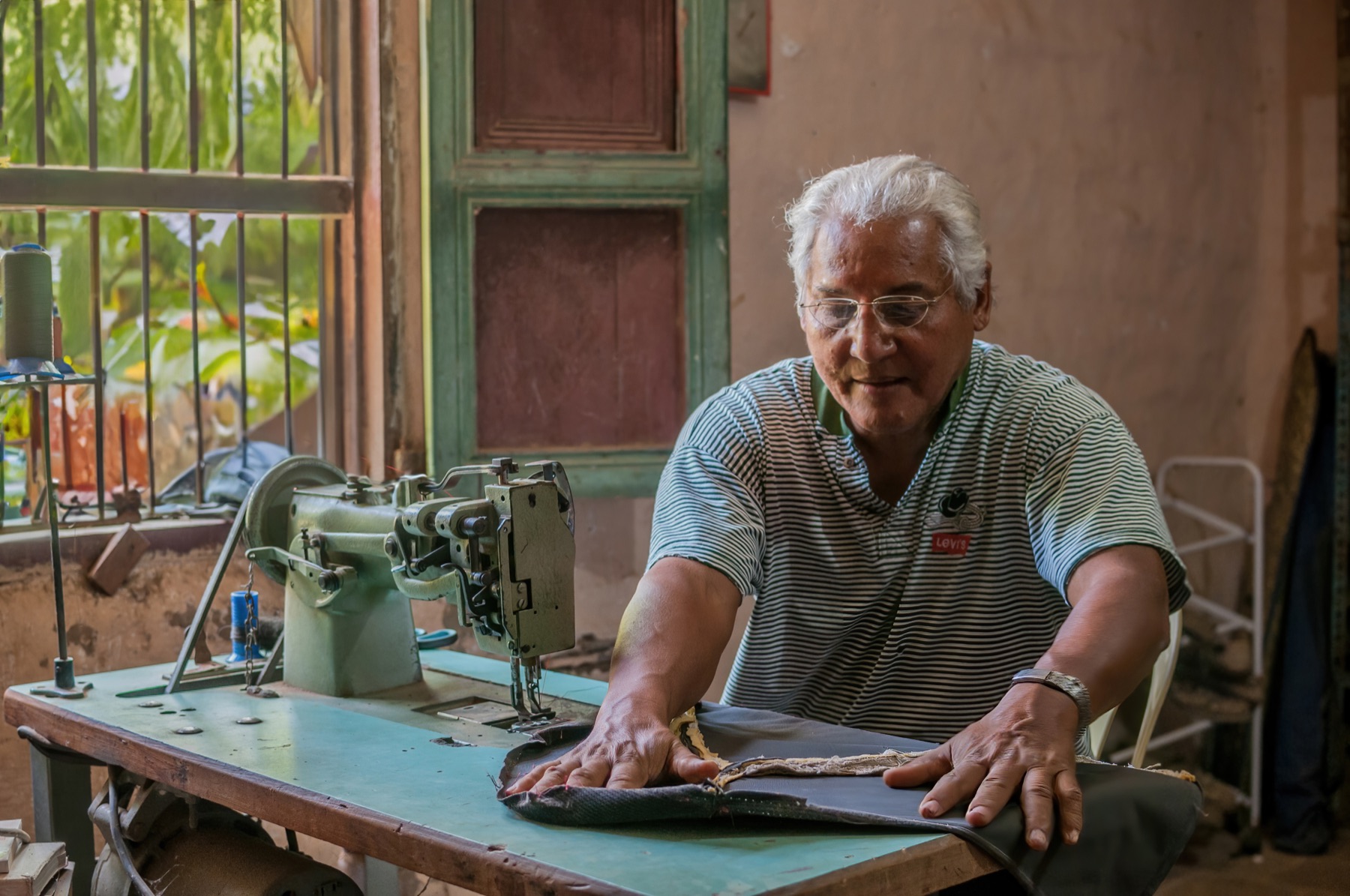 A trimmer working on a car seat at the bench