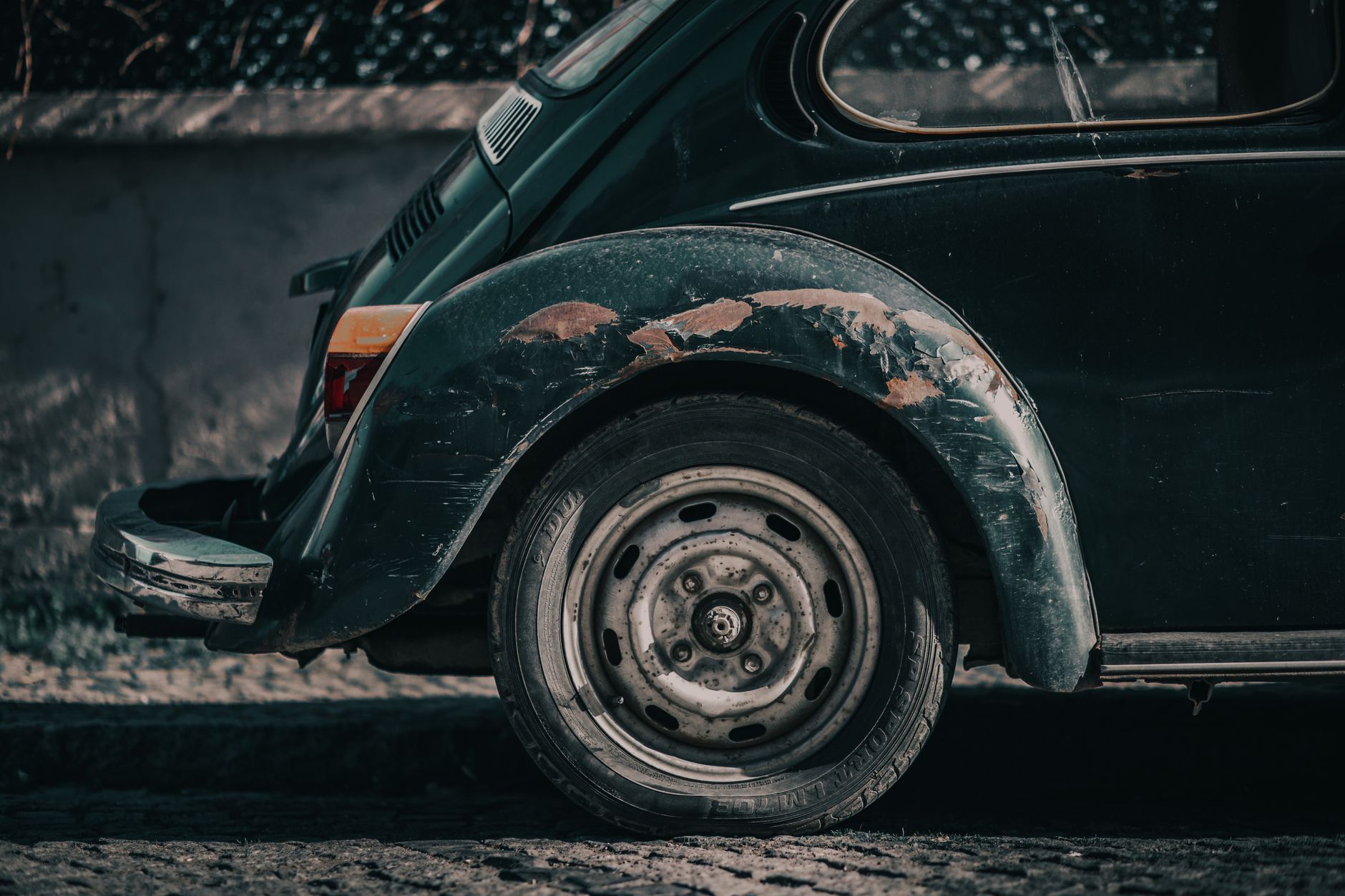 A scuffed and cracked corner of a car bumper