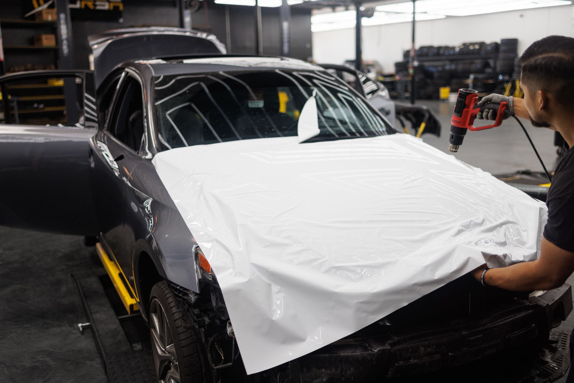 A paintless dent removal rod worked along a body line