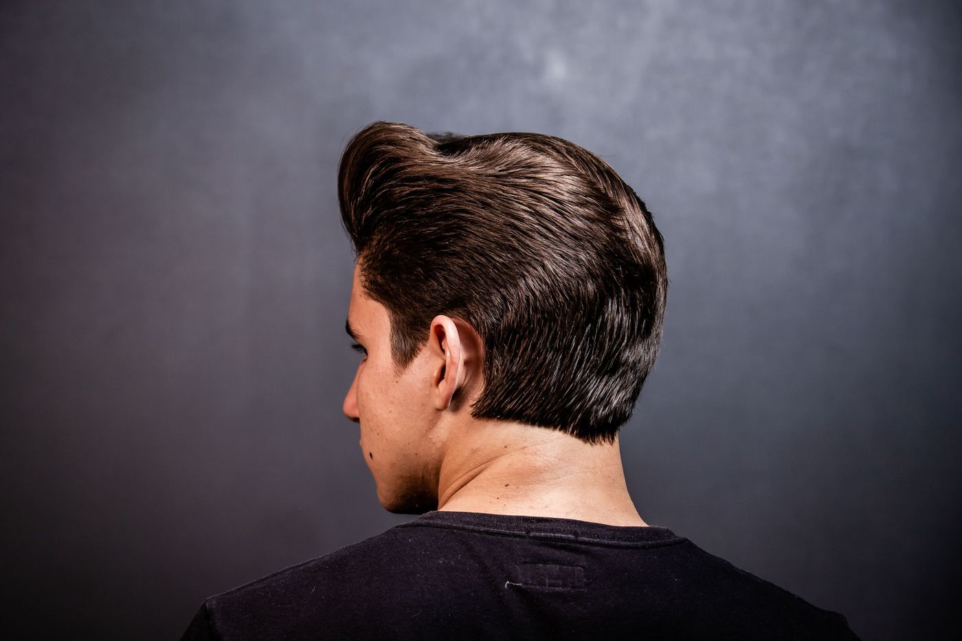 A finished pompadour from behind: tight on the sides, volume on top