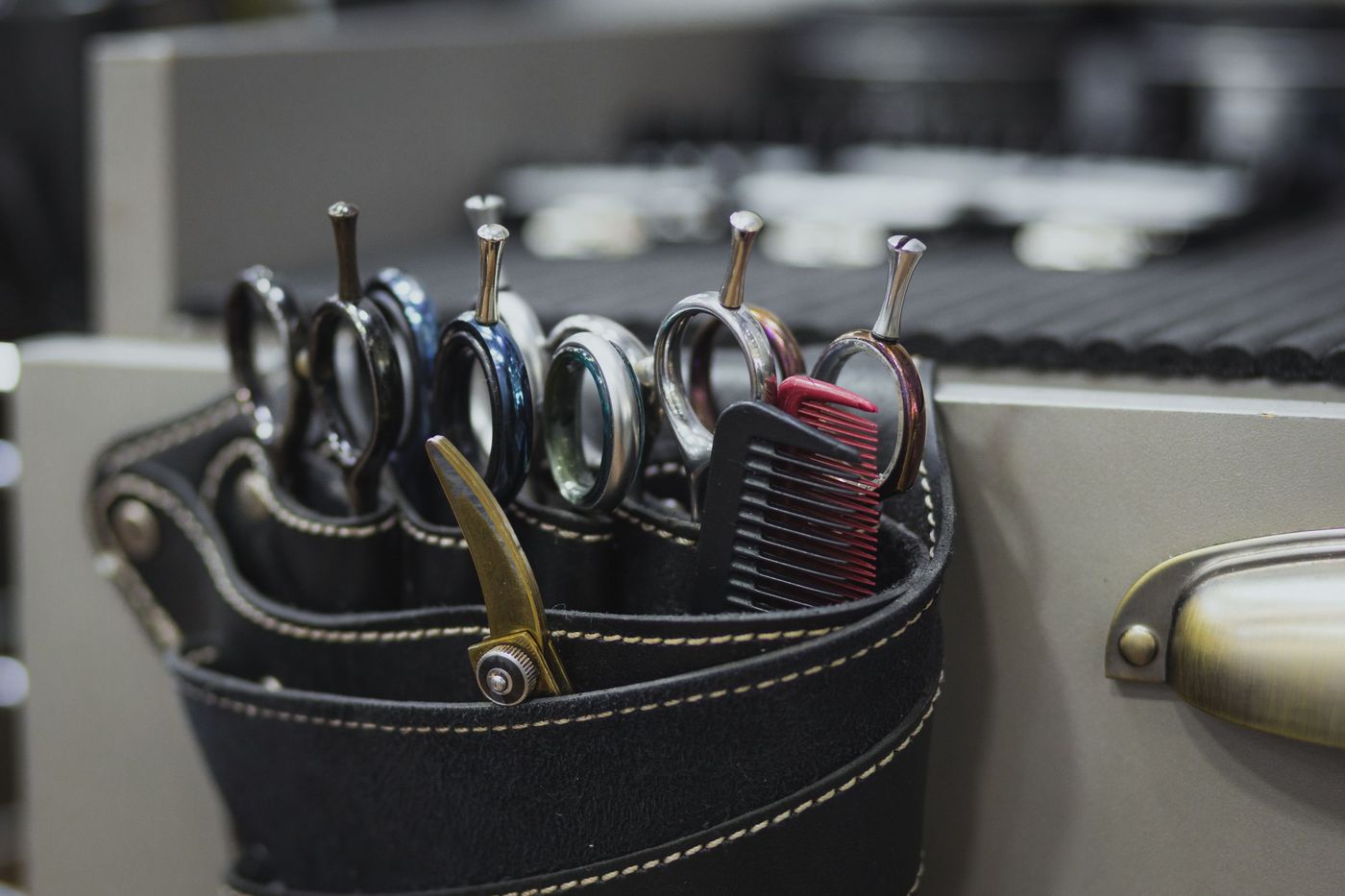 A leather holster of cutting shears hanging at a barber’s station
