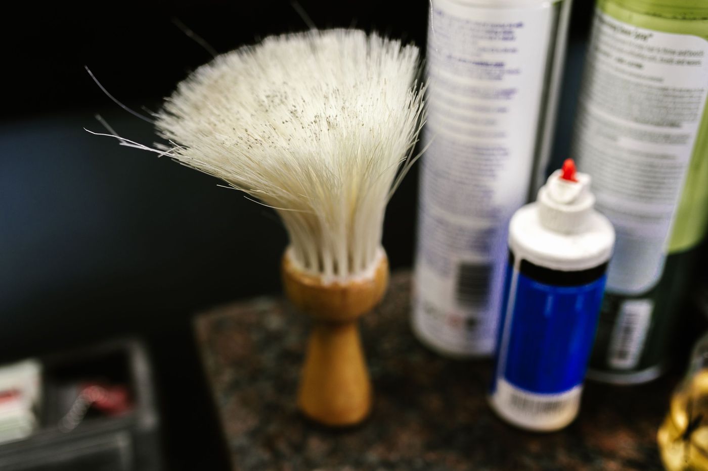 A neck duster brush on a station beside bottles of disinfectant and spray