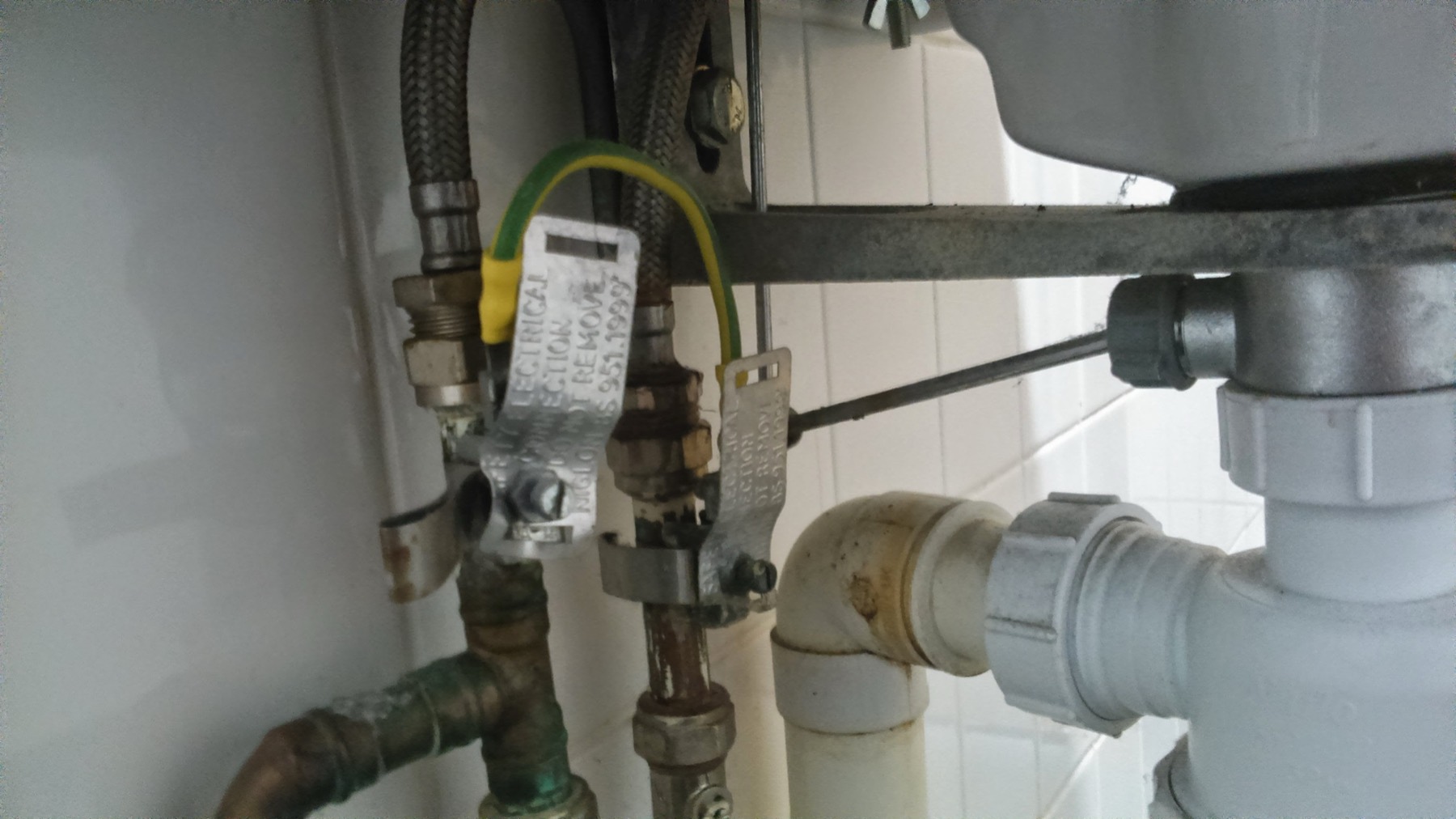 The pipework behind a kitchen sink, trap and branch line
