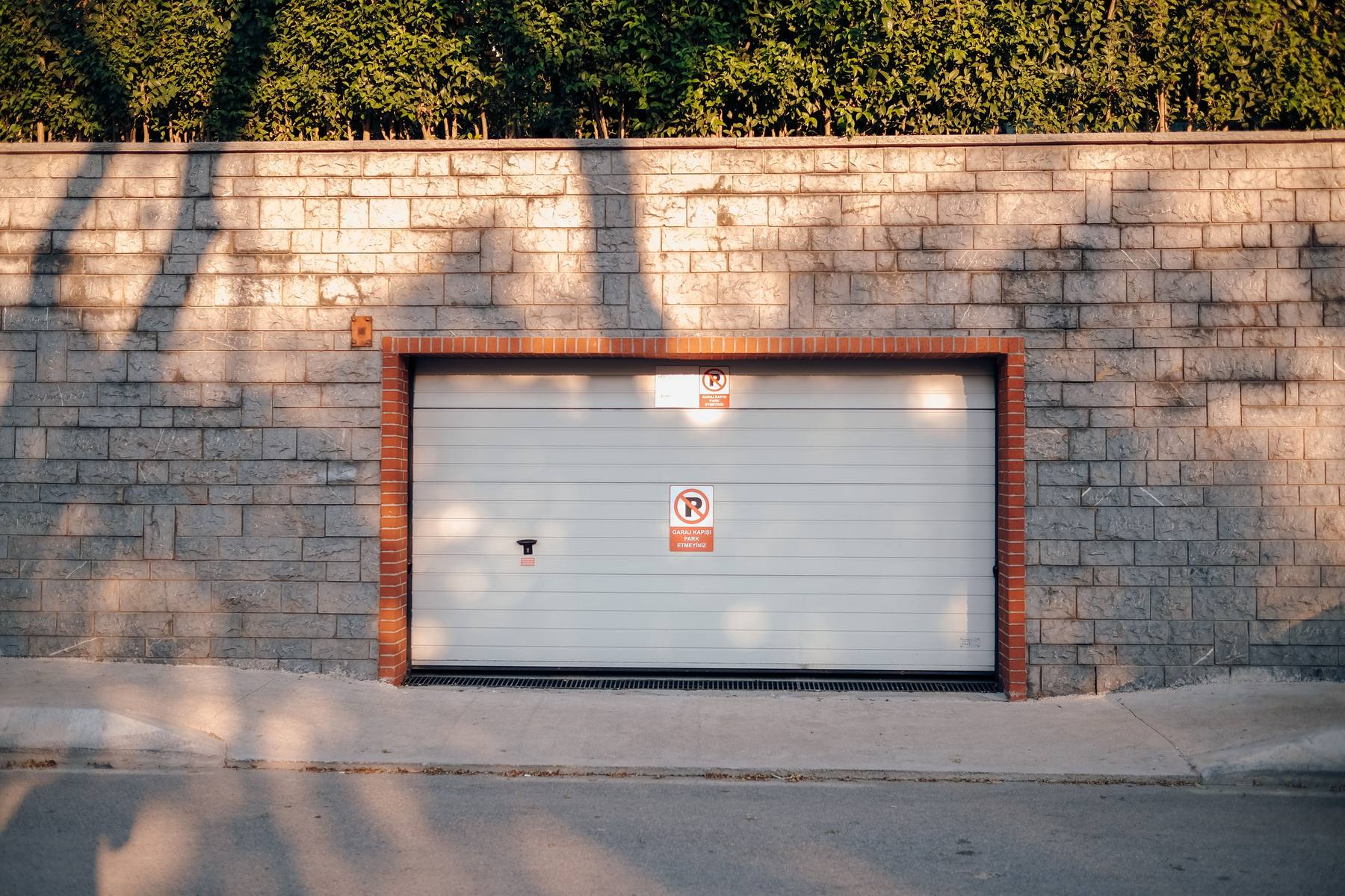 The photo-eye safety sensor at the foot of a garage door track