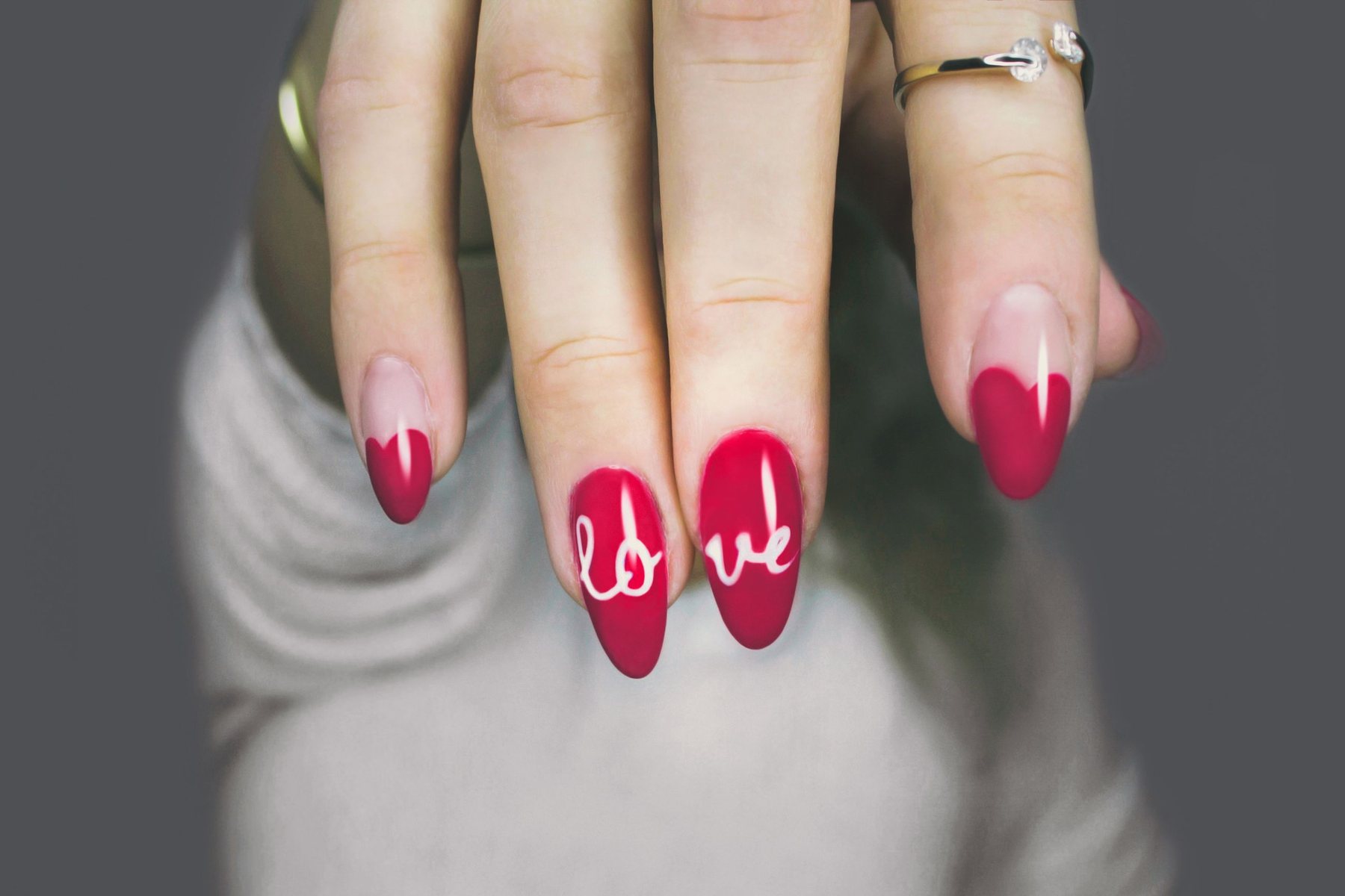 Long almond nails in red with a hand-lettered 