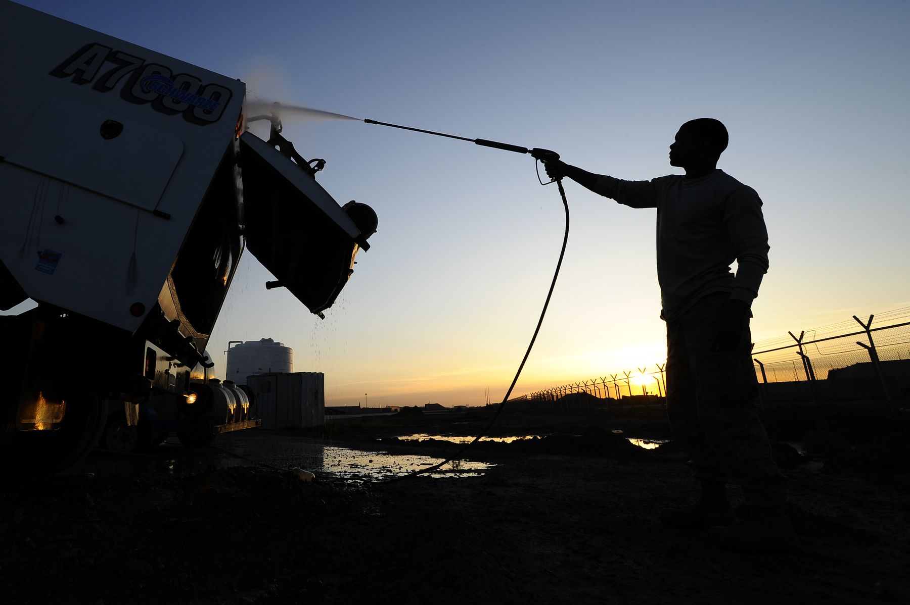 A pressure washer lance in use, spray carrying