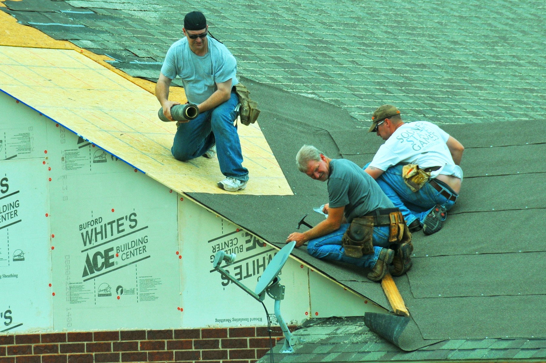 Two roofers working across fresh underlayment