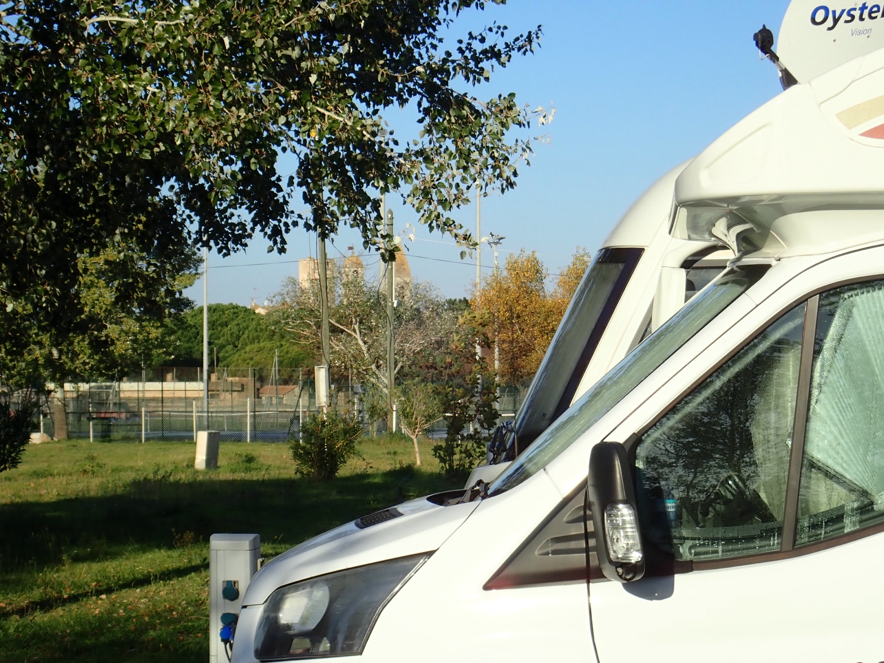 A motorhome pitched up with someone working at the side of it