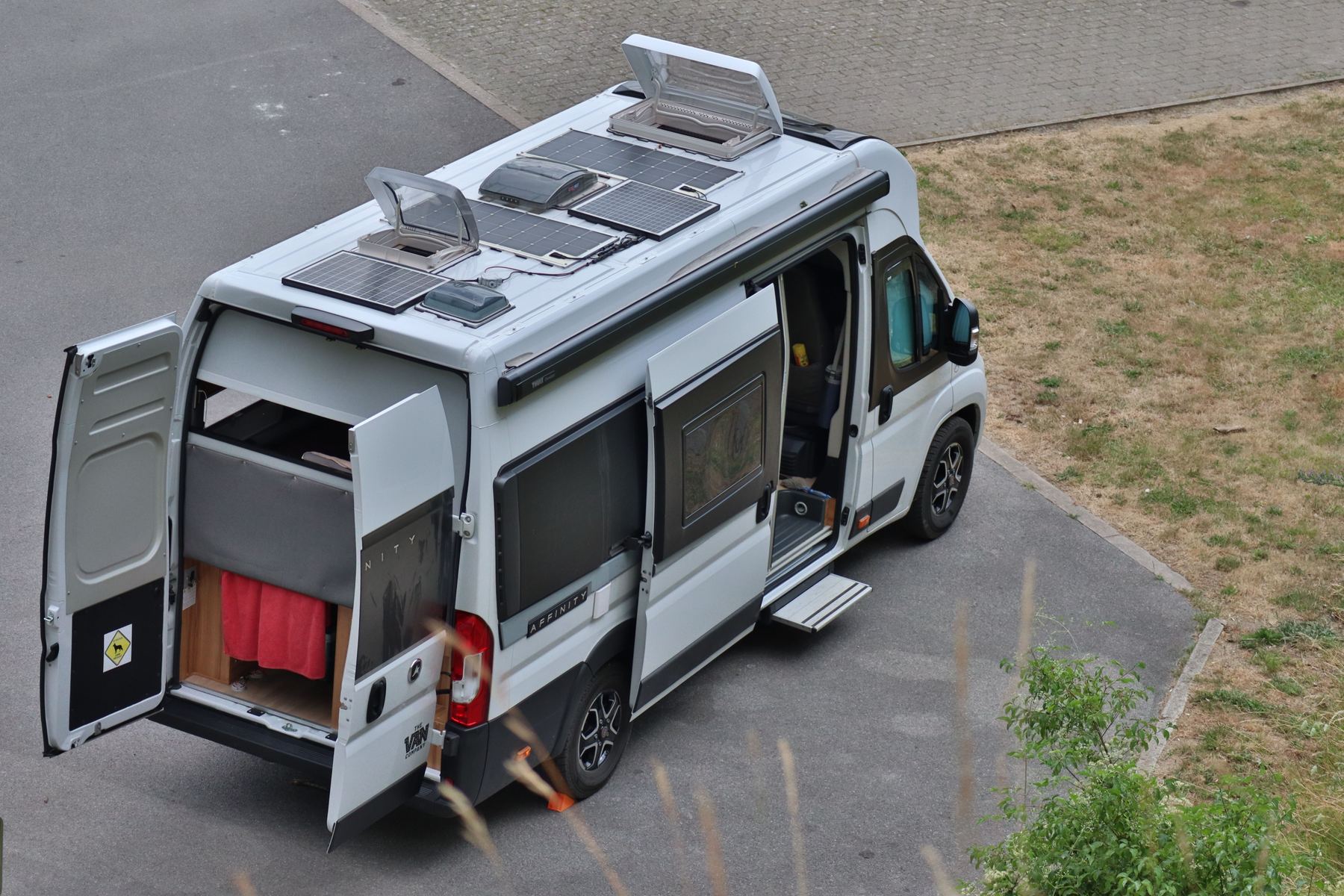 Repairing a camper van outdoors, panels open and tools out