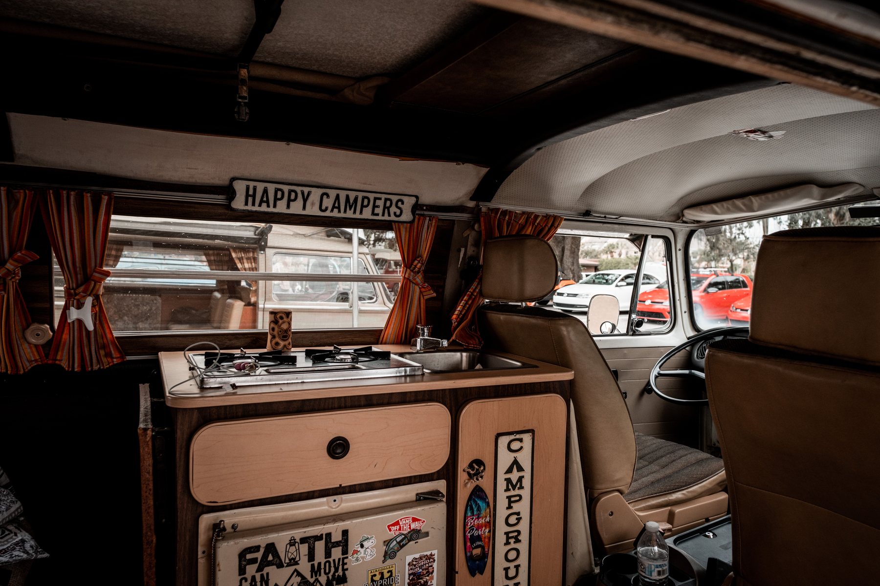 Inside a fitted camper van, bench seating and cabinetry